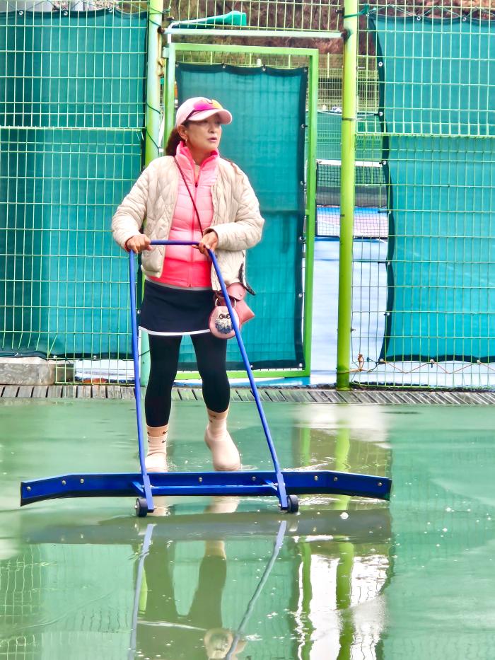 개나리부 출전한 선수가 진행위원을 도와 밀대로 코트를 정리하고 있다