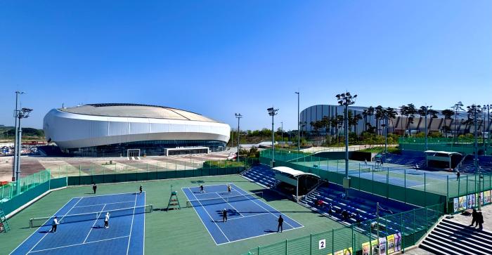 테니스 코트 건너편으로 강릉 아레나좌와 스피드 스케이트 경기장이 보이고 있다