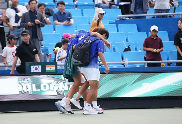 권순우 선수가 동료들의 부축을 받으며 코트를 벗어나고 있다